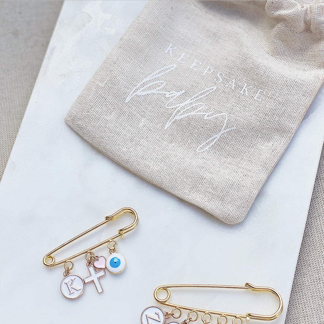 A meaningful and significant way to express your love and care for your baby's well-being, while also offering protection and peace of mind. Our Evil Eye charm is available in White (with blue centre), Blue, or Pink. The Evil Eye Charm is traditionally known for protecting against bad luck and negative energy. All of our Keepsake Baby Pins are custom made. Each Pin is beautifully packaged and ready for gifting. Our keepsake pins make the perfect gift for newborns and parents, christenings and baptisms.