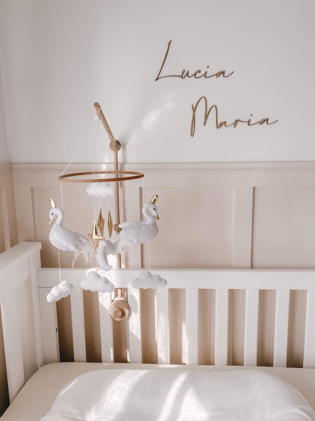 Image of a charming baby nursery room adorned with a delicate swan-themed mobile. The room features soft pastel colors, plush toys, and a cozy crib, creating a serene and inviting atmosphere for a baby.